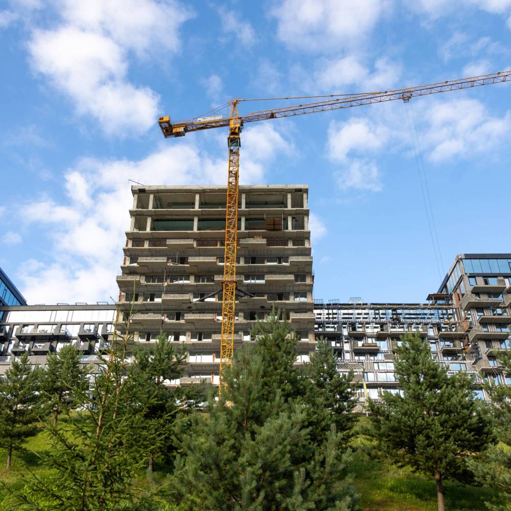 A tower crane rises above an unfinished residential block against blue sky. Modern architecture, city development and real estate progress. SSUCv3H4sIAAAAAAAAA41Py46DMAz8F5+DZCi0kF+pegjEUKtAqsRptUL591Uo1V73NmN7Ht6ALWgwY4NVU2HRlpe6KMsRi7Y/t8VYjtXFdtW5axEUWCMEujzViBfEsm5OXYeIqKA3gQfQG/A8xyDeCLsVNCrwtFryOyTL4jybGTQmBUGMxEAB9JYUDEZocp53/vW7bnkOGkBBiH0GSf1zdlNgJlqHn+yfcpGZzB53vSl4vIX8cmQ7ueeKGT49D7xOR6cYxC0fvDrJ2j1B3PBge4g/b9w5iPM5C+JzdsaSPdaxX1jkSz29mN5/1ymlX7z5cqmEAQAA